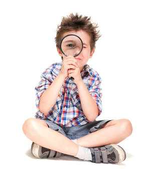 Attentive little boy with weird hair researching using magnifier