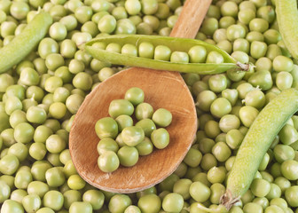 Fresh raw green pea  seeds on wooden spoon