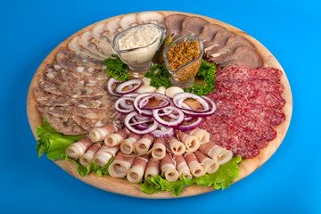 the cut sausage, bacon with mustard and onions on a plate