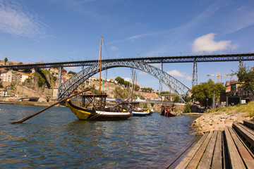 Tradicional vintage port transporting boats near famous bridge P