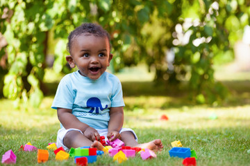 Little african american baby boy playing in the grass - 42110124