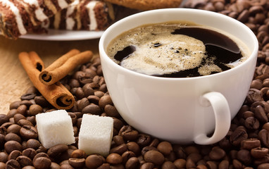 Coffee cup, beans, sweets, cinnamon and sugar cubes