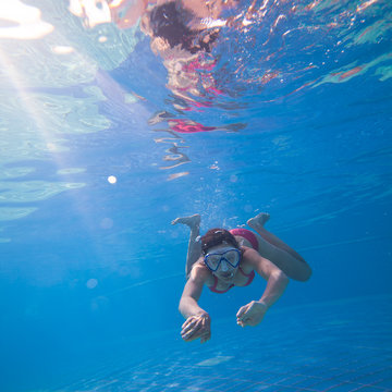 Underwater swimming: young woman swimming underwater in a pool © lightpoet