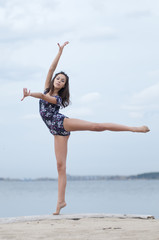 Obraz na płótnie Canvas Młoda dziewczyna taniec gimnastyka na plaży