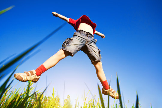 Boy Jumping Against The Blue Sky