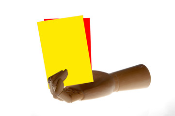 a wooden hand is holding a yellow and red card