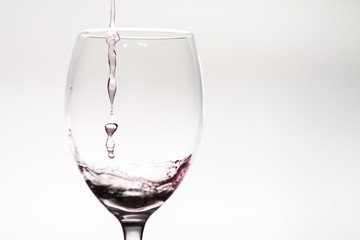 Drop of wine falling into a wineglass
