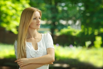 Female standing with folded hands looking away outoors