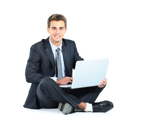 Isolated seated young businessman using a laptop