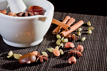 Nuits and cinnamon sticks in front of a mortar