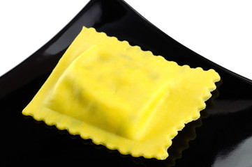 Ravioli filled with spinach and ricotta on a black plate