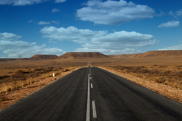 Fototapeta na wymiar paved road in the desert with clouds Namibia Africa