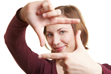 Frau bildet Rahmen mit Fingern