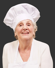 senior cook woman smiling over black background