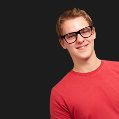 portrait of young man smiling wearing glasses over black backgro