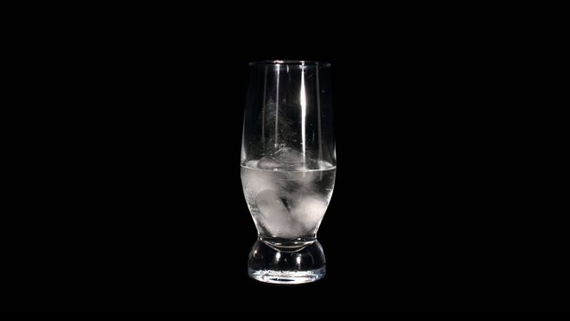 Timelapse of melting ice cubes in a glass. reversing