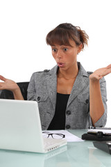 Confused businesswoman sat at desk