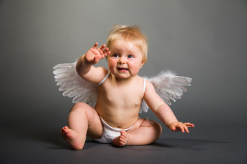 Infant baby with angel wings on neutral background