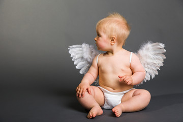 Infant baby with angel wings on neutral background
