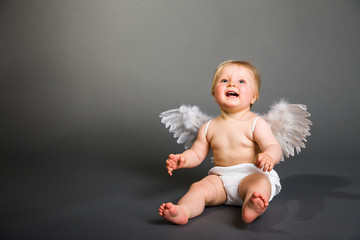 Infant baby with angel wings on neutral background
