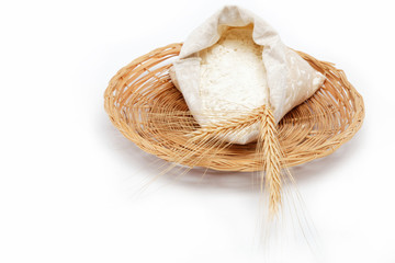 Flour and wheat grain on a wicker basket.
