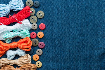 Blue jeans background with buttons and threads.