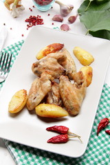 ali di pollo arrosto su tavolo di legno bianco