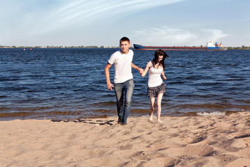 Fototapeta na wymiar Loving couple running on beach
