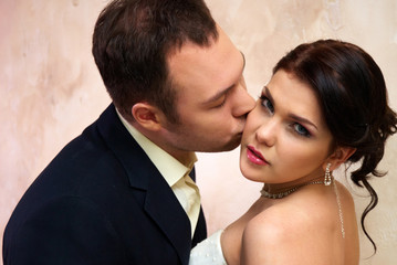 groom kisses bride in empty room