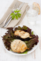 grilled fish with salad on the white plate