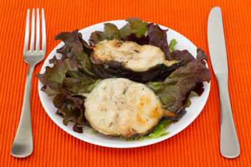 grilled fish with salad on the white plate