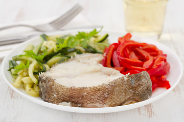boiled fish with vegetables and glass of wine