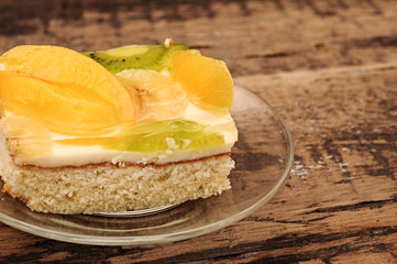 Close-up  of apricot cake on glass plate on wooden table