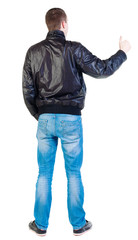 back view of standing young  man showing thumb up