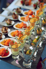 Spoons and glasses with seafood snacks