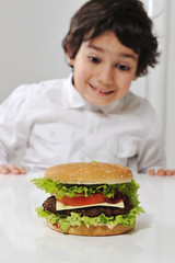 Little Arabic boy with burger © Jasmin Merdan