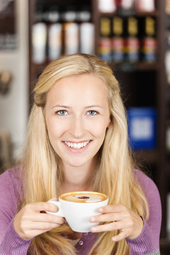 blonde frau mit einer tasse cappuccino