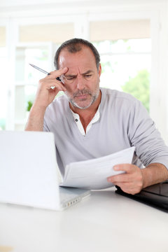 Senior man being puzzled with tax documents