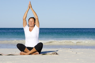 Fototapeta na wymiar Meditating, relaxing, exercising woman at beach