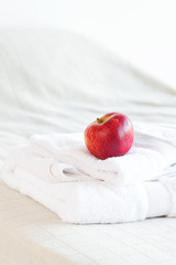 apple lying on towels on the bed