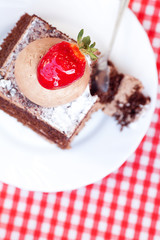 beautiful cake with strawberry on plaid fabric
