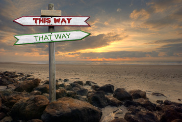 Double directional signs on a beach – This way / that way