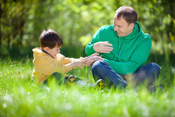 Naklejka na ściany i meble Happy father playing with his little son outdoors