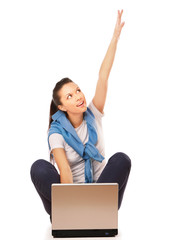 Cheering young woman sitting on the floor with laptop