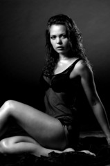 Beautiful young woman in wet shirt on dark background