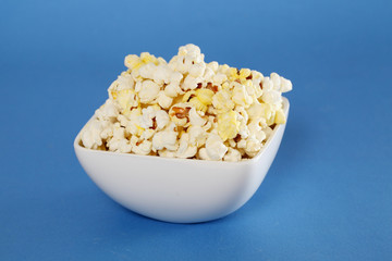 Delicious popcorn bowl on blue background