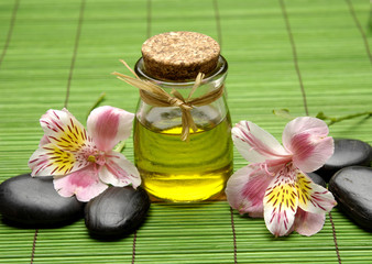 Fototapeta na wymiar Beautiful orchid with massage oil and stones on mat