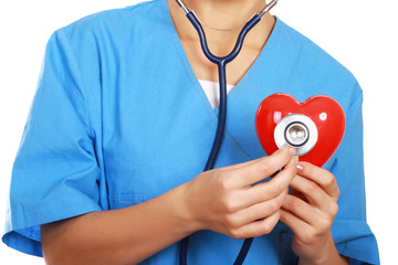 Female doctor with stethoscope holding heart