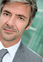 Fototapeta premium Portrait of businessman standing in front of modern building