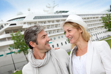 Happy romantic couple standing in front of cruise boat
